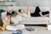Father and daughter bonding in cozy living room with books and games, creating joyful family moments.